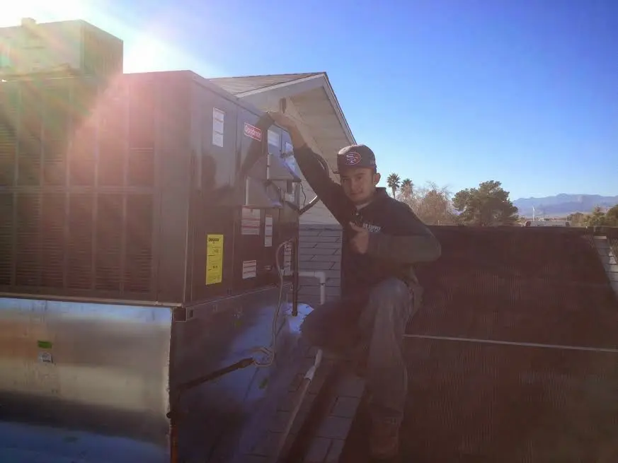 HVAC technician performing Boiler Repair on a rooftop unit in Gainesville